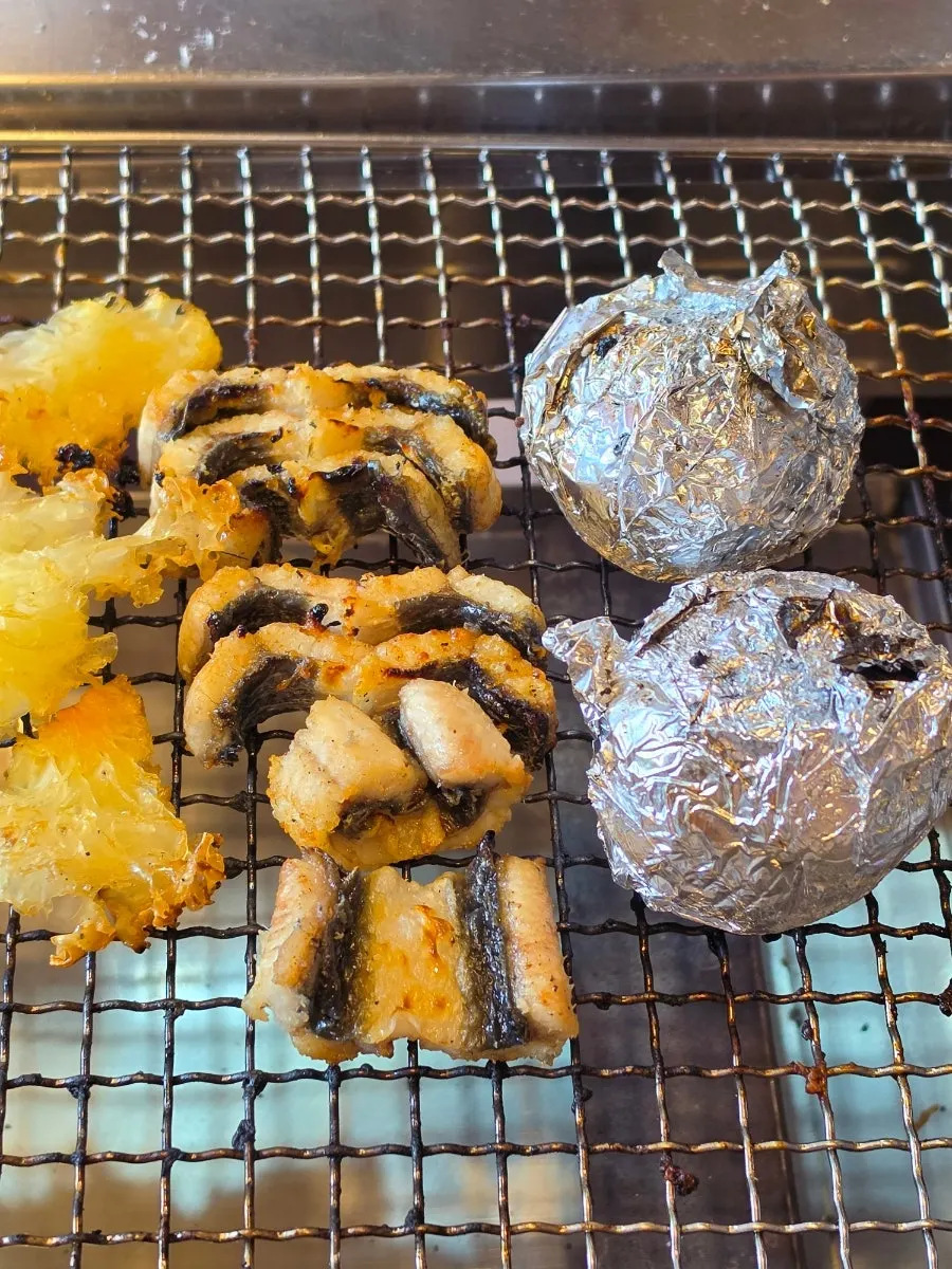 Two roasted potatoes cooked in the charcoal embers