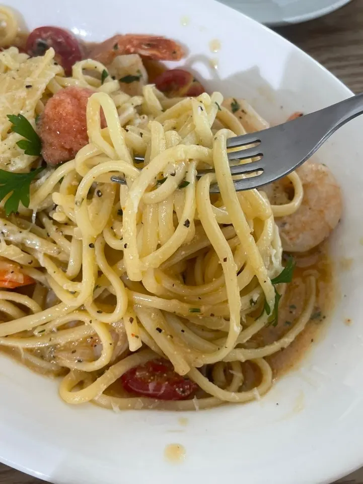 Lifting a forkful of mentaiko shrimp oil pasta