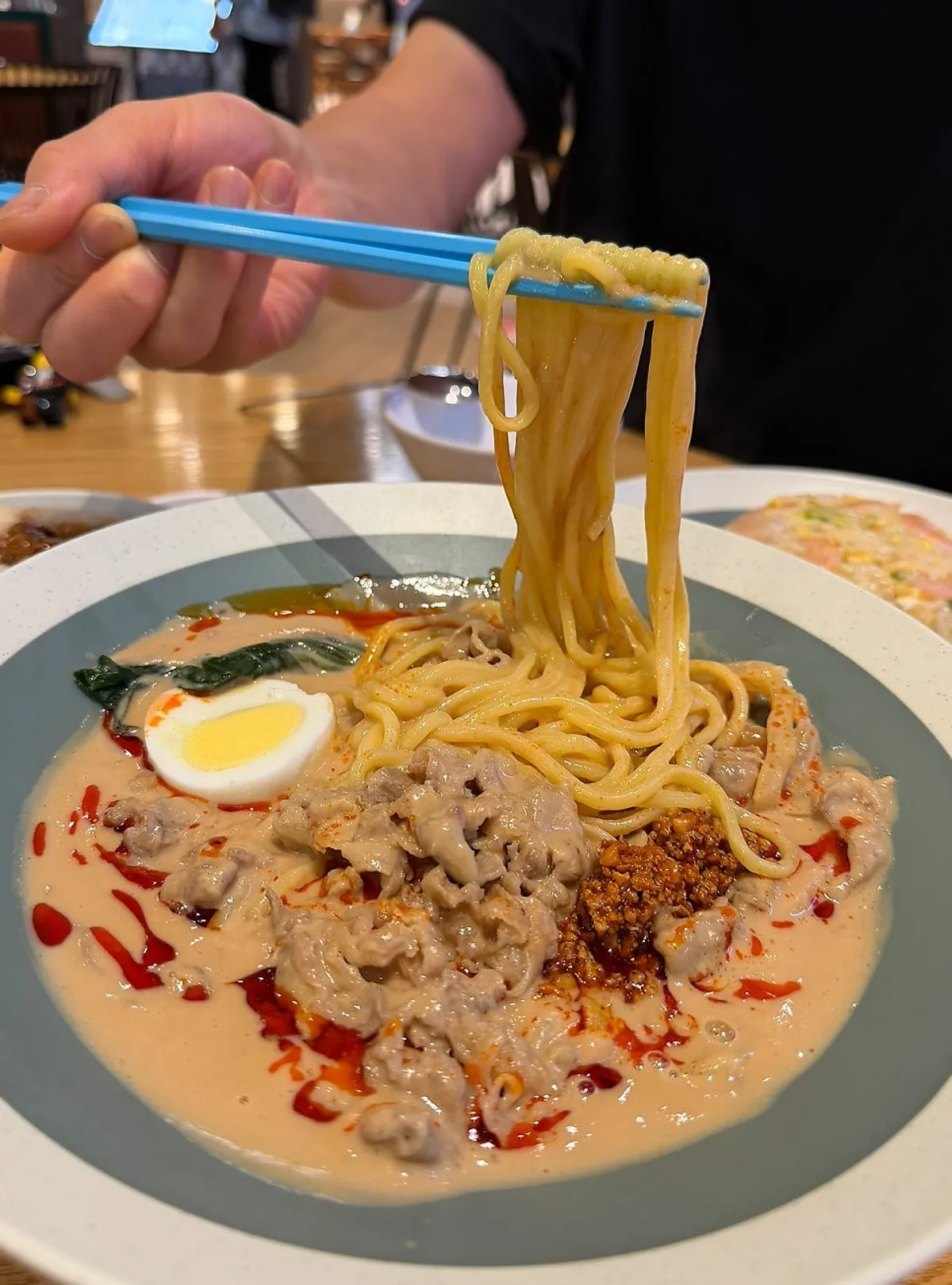 Noodle strands of beef tantanmen showing peanut sauce and chili oil