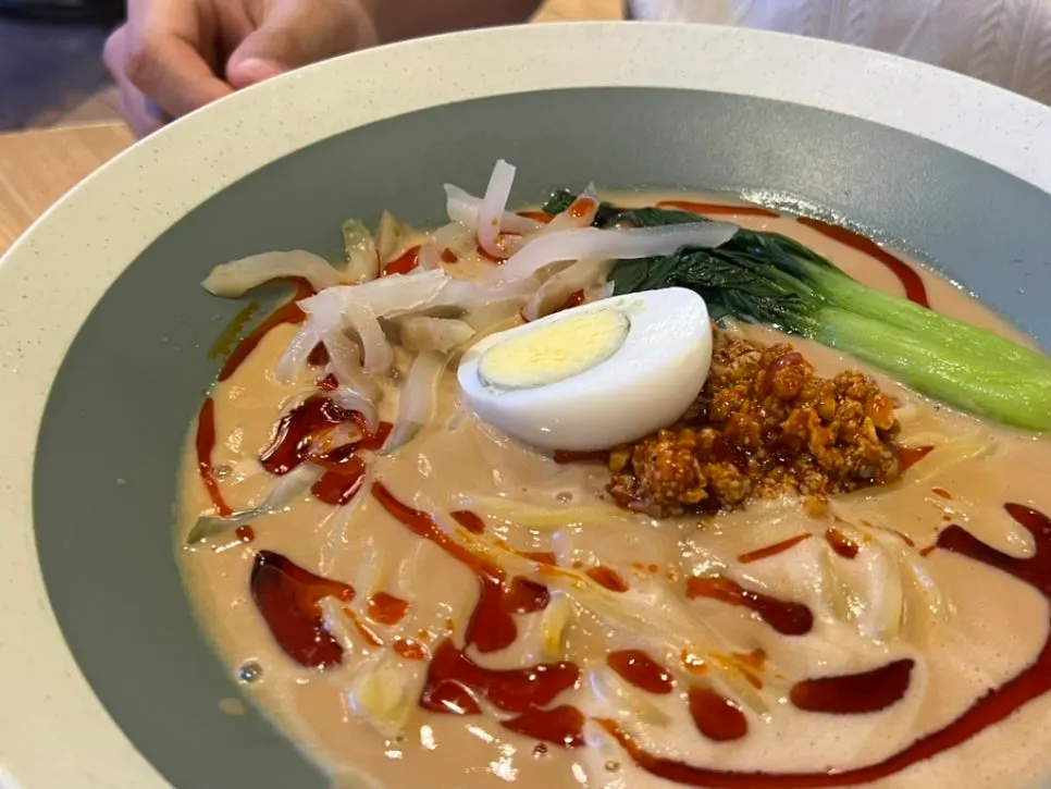 Close-up of tantanmen topped with egg and pickled mustard greens