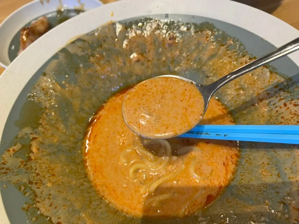 Tantanmen broth with visible bits of peanut