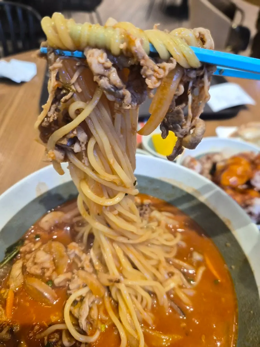 짬뽕 면과 소고기를 함께 집은 모습