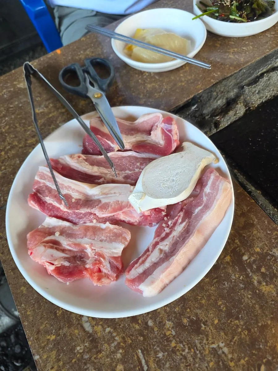 A plate of raw pork belly before grilling