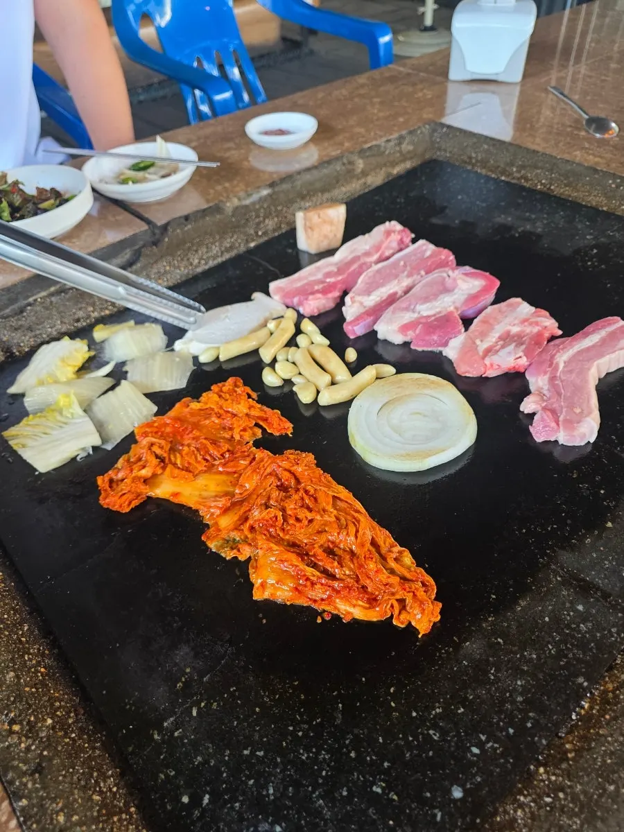 Pork belly grilling with onion, mushroom, and rice cake