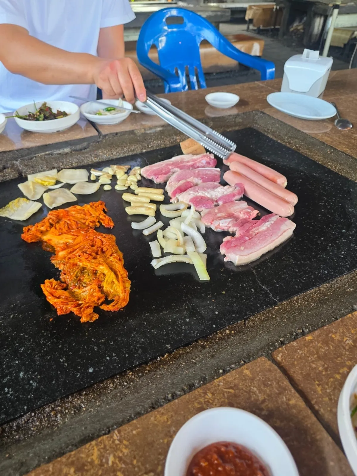 Pork belly and aged kimchi cooking together on the stone plate