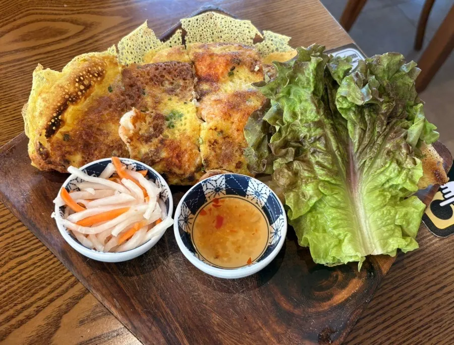 Bun cha meat dipped in sauce alongside the noodles