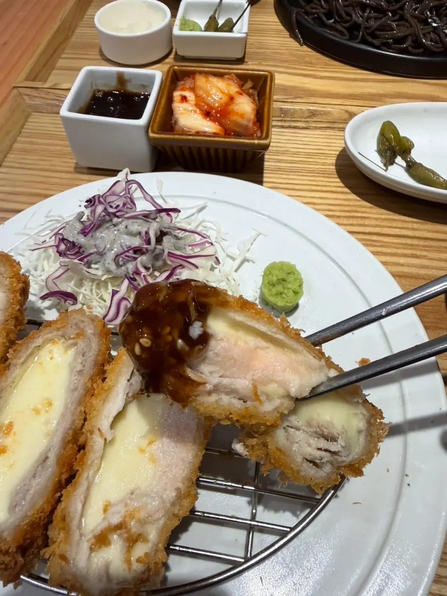 Cheese stretching as a piece of cutlet is lifted with chopsticks
