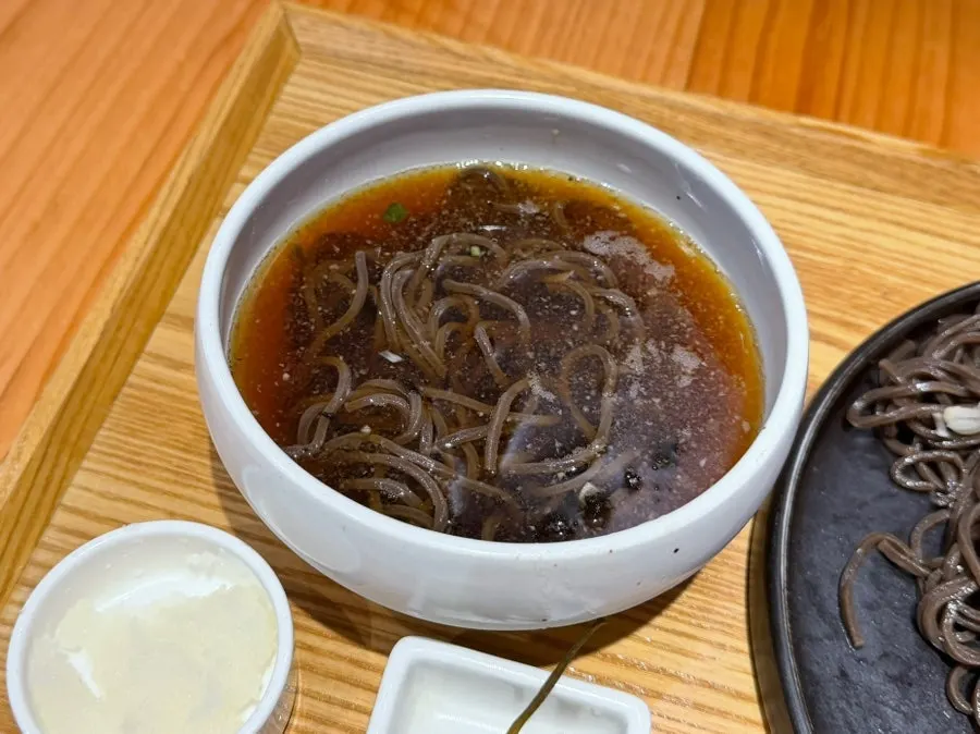 Buckwheat soba noodles lifted with chopsticks