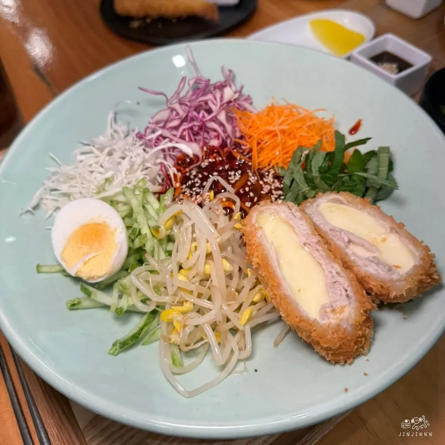 A piece of cheese pork cutlet served with the bibim jjolmyeon