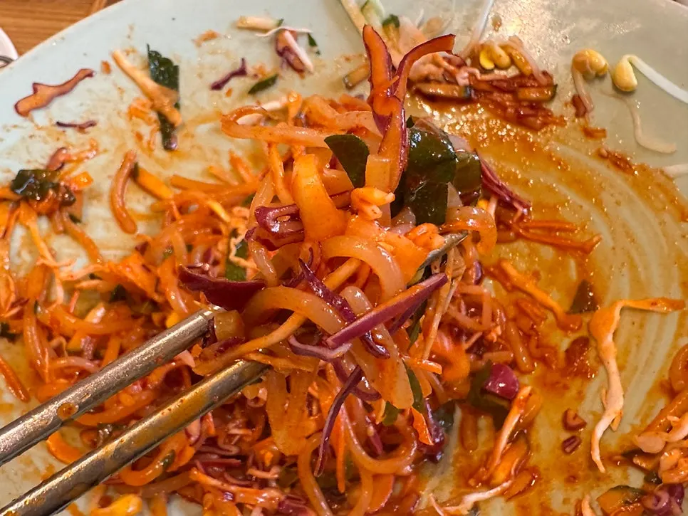 A chopstick-full of mixed Chilseong bibim jjolmyeon
