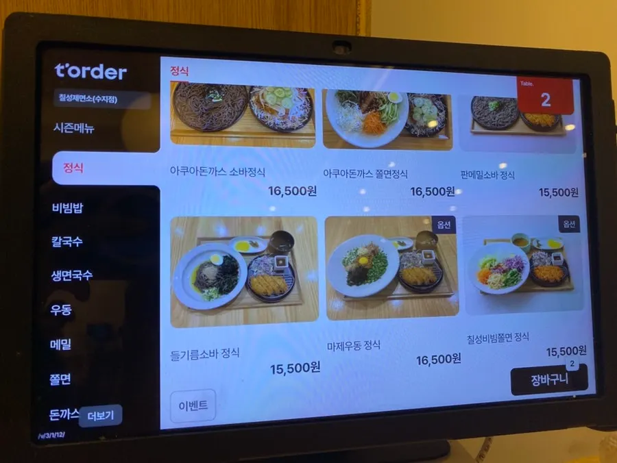우드톤 테이블과 의자가 놓인 매장 내부
