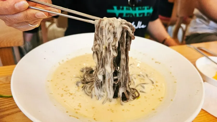 Close-up of buckwheat noodles in soy milk broth