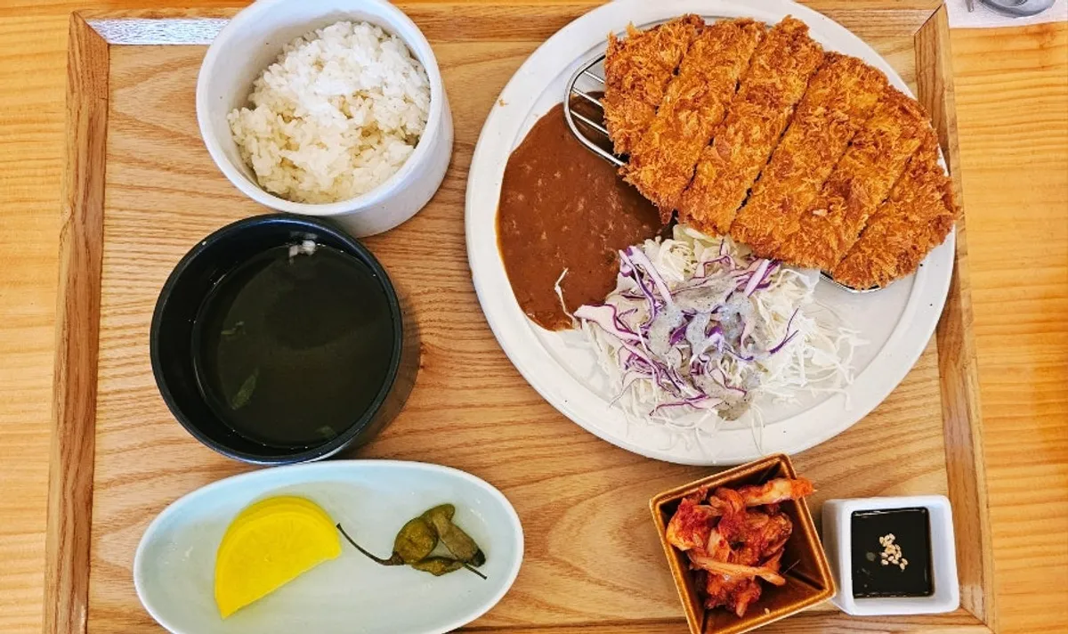 Whole pork loin cutlet with sauce on a wooden tray