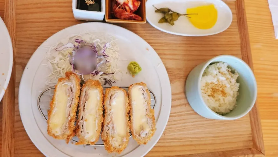 Cheese pork cutlet with oozing cheese and a bowl of rice