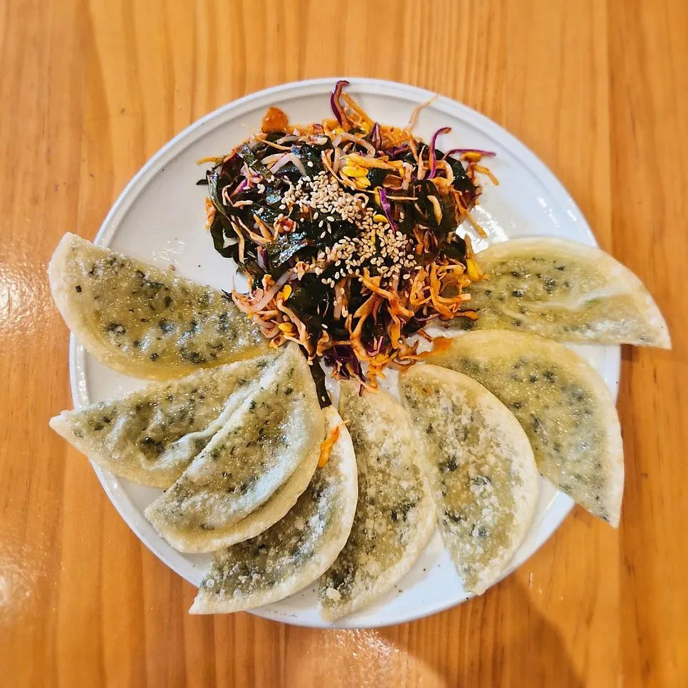 야채무침을 올린 납작만두 한 접시