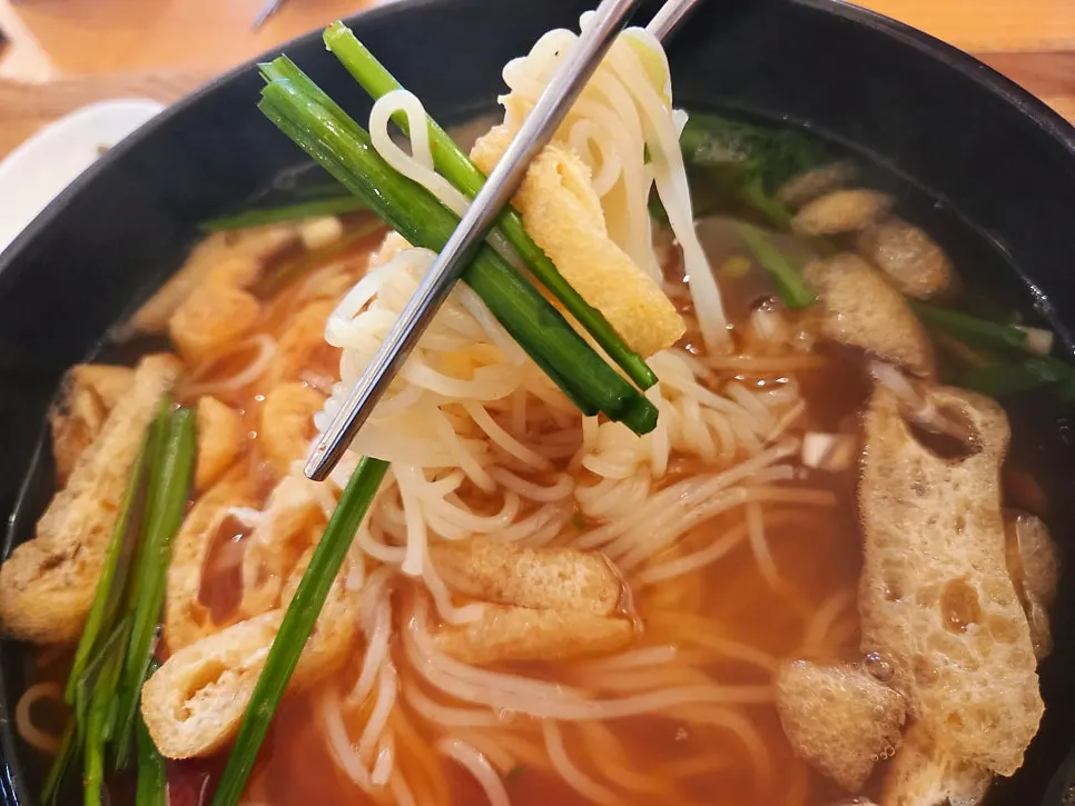 Lifting the fresh noodles from the hangover noodle soup