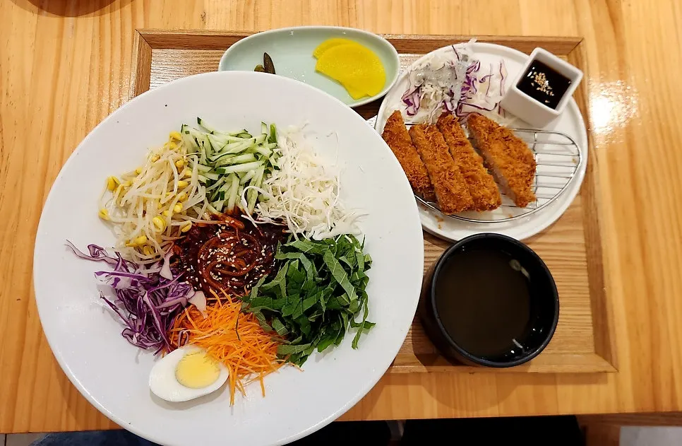 Table with bibim jjolmyeon and pork cutlet together