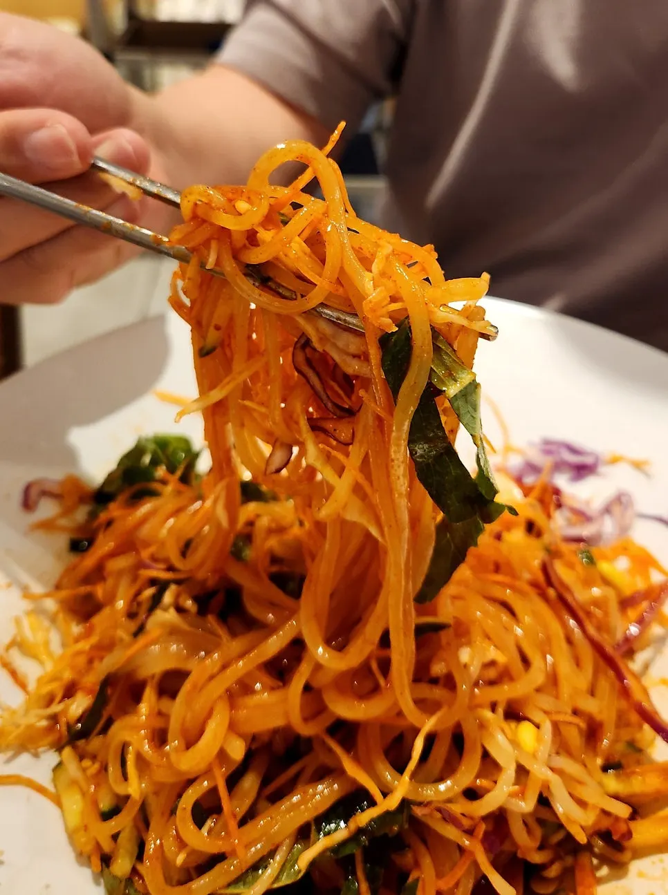 Lifting up a strand of the bibim jjolmyeon noodles
