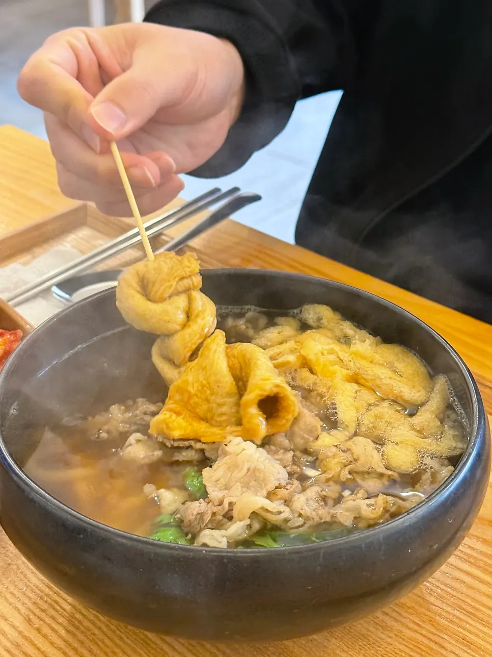 우삼겹과 우동 면이 보이는 국물