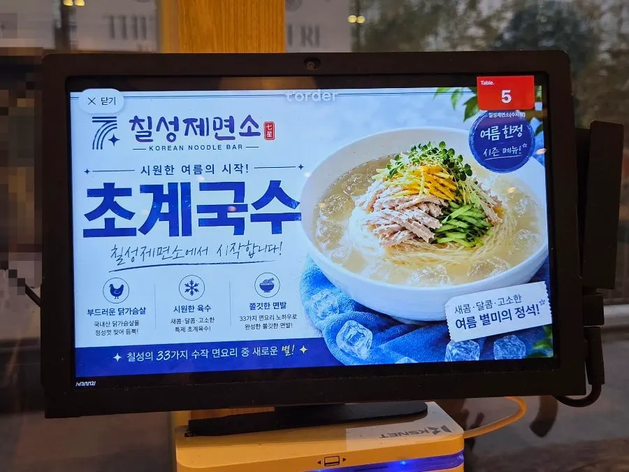 Menu board at Chilseong Jemyeonso listing noodle dishes and snack food together