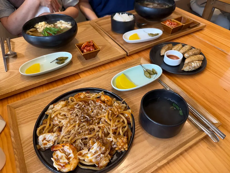Full spread of gukbap, noodle soup, yaki udon, and mandu