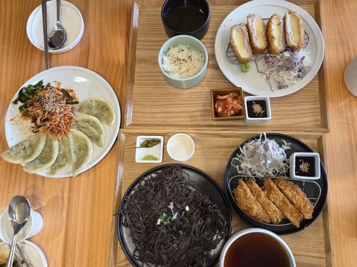 Full table spread with real cheese pork cutlet, buckwheat soba set, and spicy mixed mandu