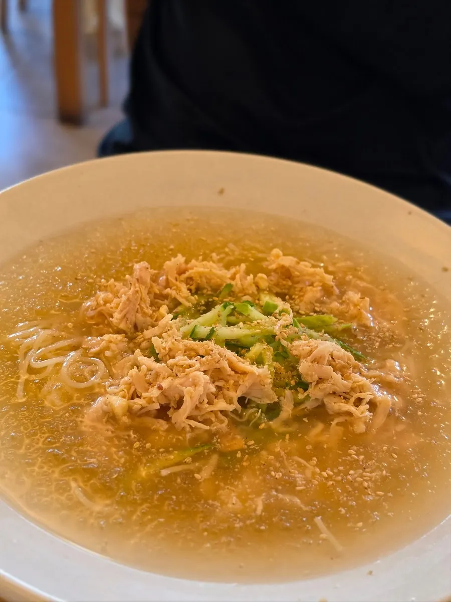 Bowl of chogye guksu topped with shredded chicken