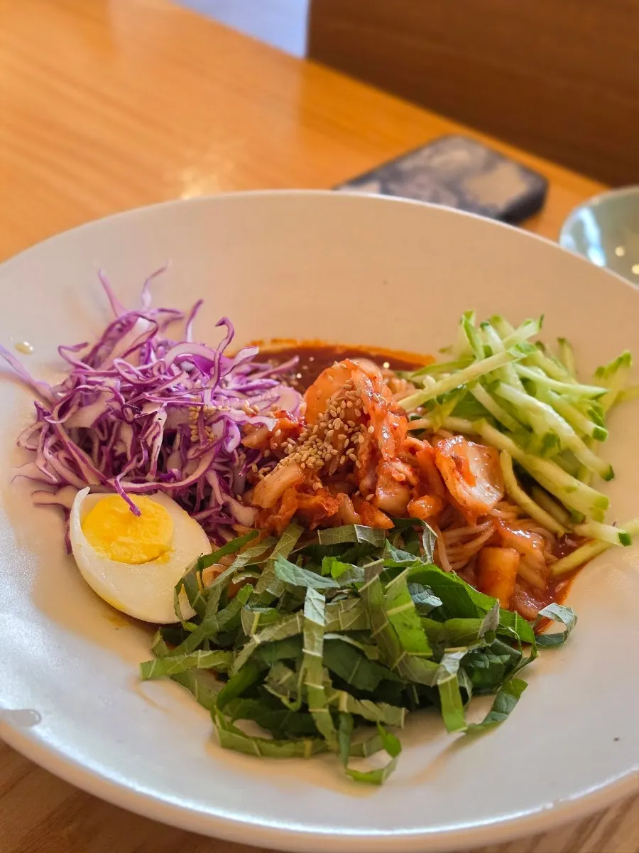 Fresh kimchi bibim guksu topped with kimchi and perilla leaf