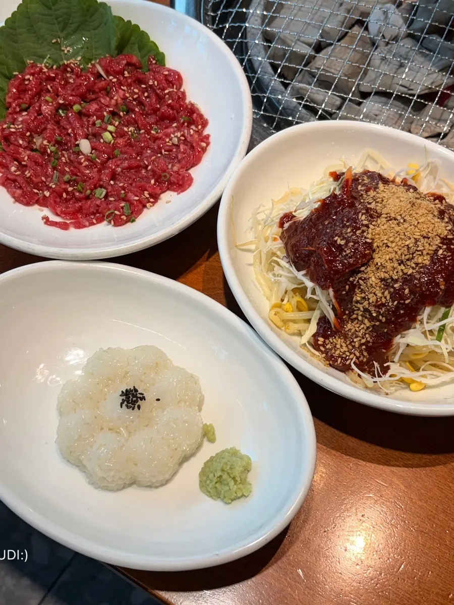 Table spread with seasoned crab, japchae, and other banchan