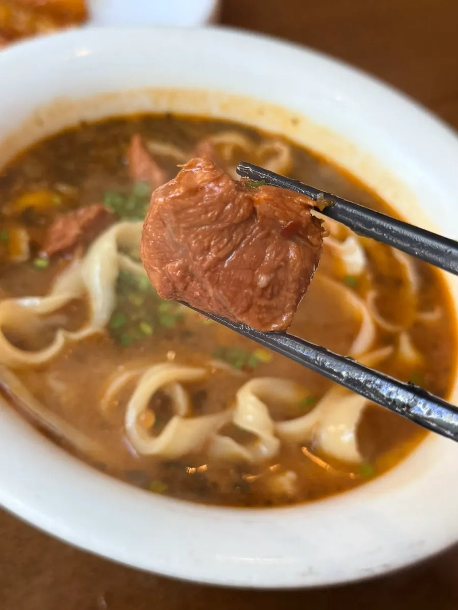 Close-up of beef knife-cut noodles in rich meat broth