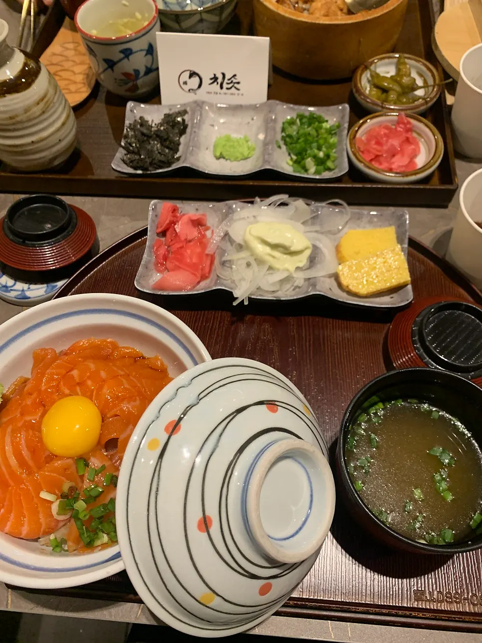 A bite of eel rice bowl with scallions and wasabi