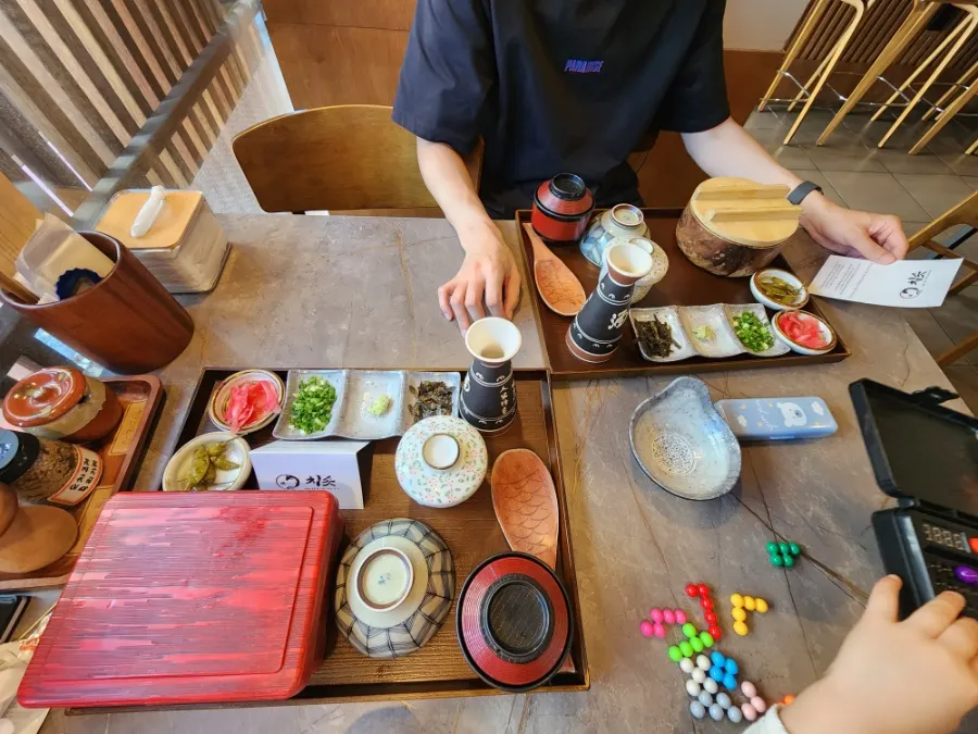 Table setting with a tray of side dishes, egg custard, and miso soup