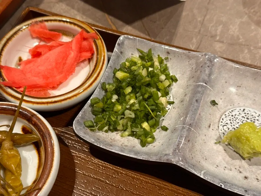 Eel rice bowl topped with seaweed, chives and wasabi