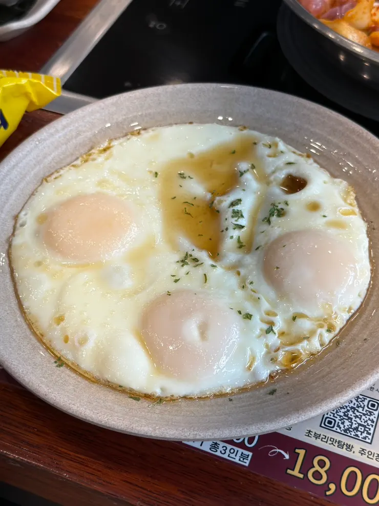 Three runny fried eggs served on one plate