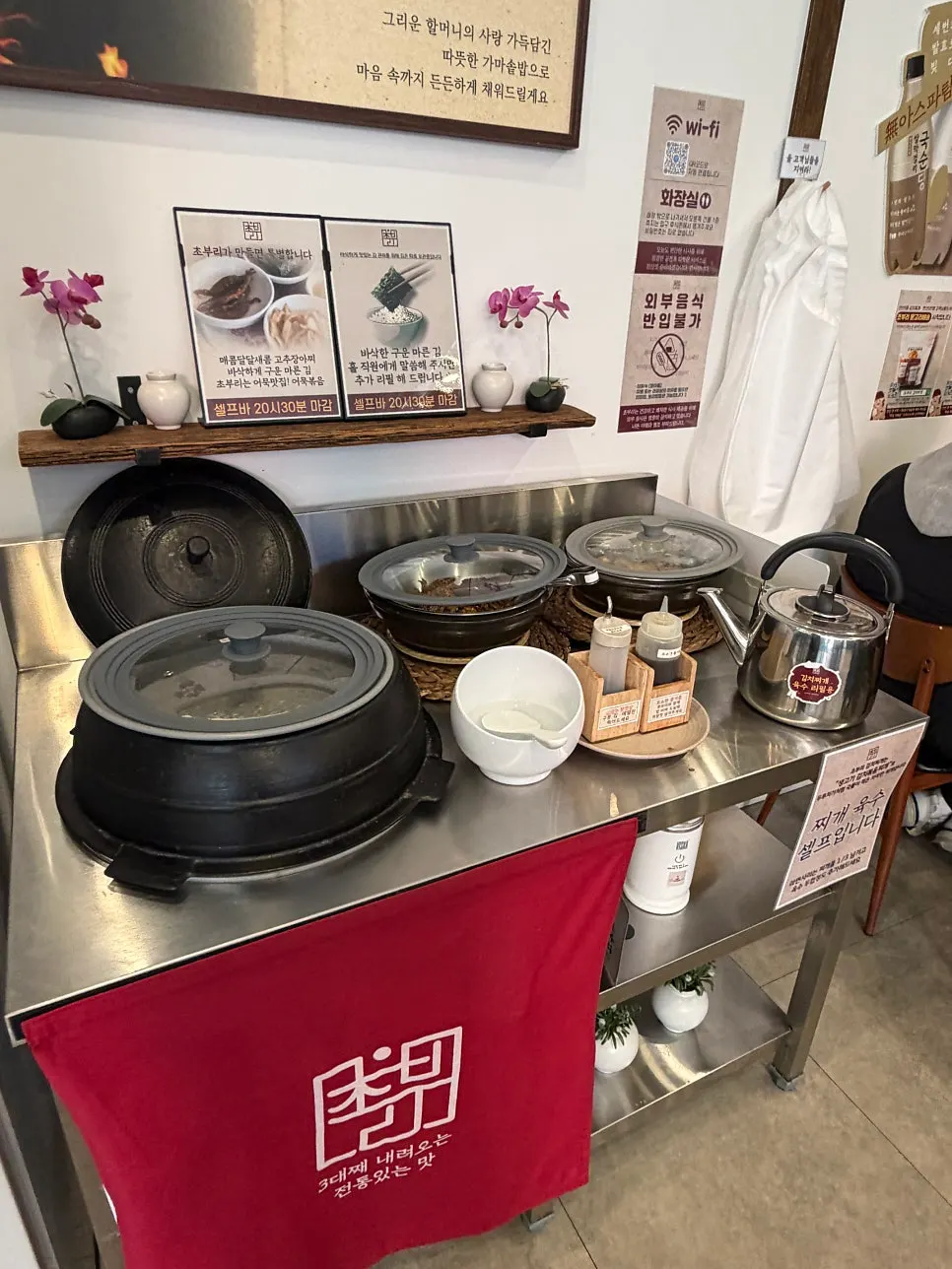 Self-serve bar with rice, side dishes, and broth