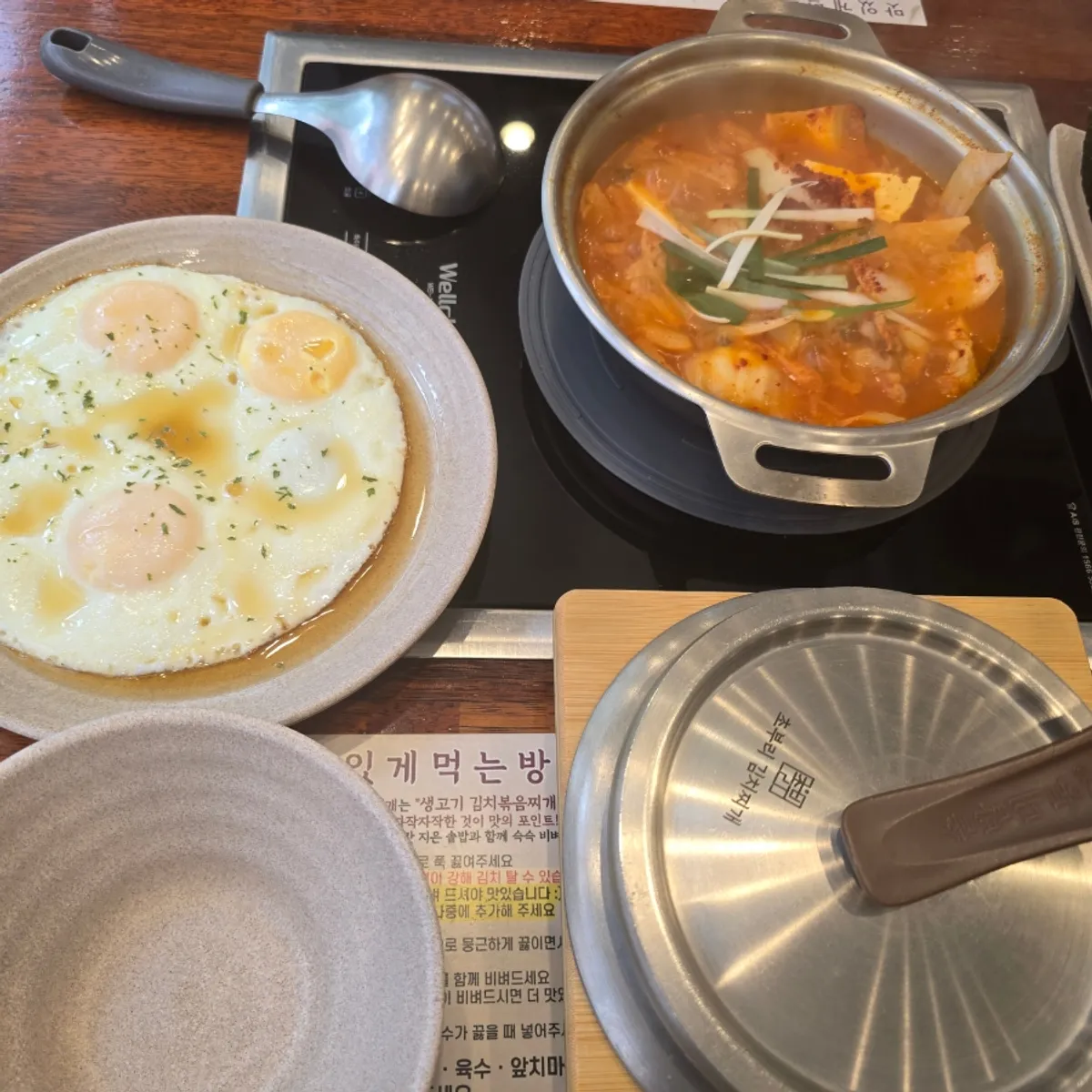 A full set with perilla oil fried egg, stone-pot rice, and kimchi jjigae