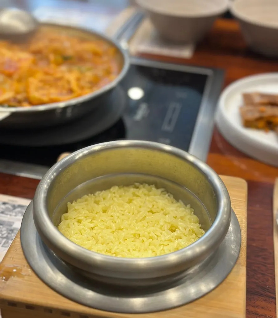 Table spread with yellow turmeric stone-pot rice and kimchi jjigae