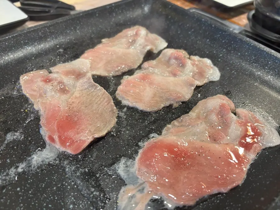 Golden-brown frozen pork belly and pork collar cooking