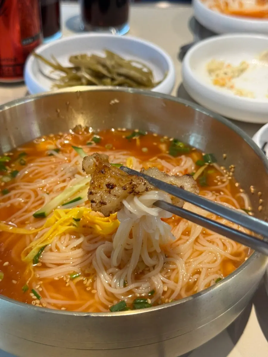 김치말이국수 면에 대창을 돌돌 말아 먹는 모습