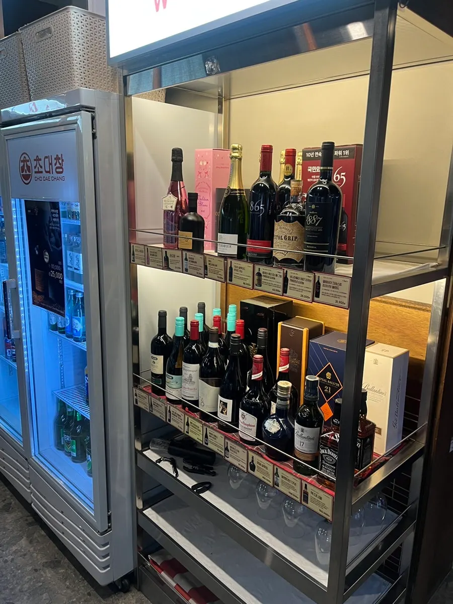 Interior of Chodaechang Baekseok Branch with liquor bottles on display