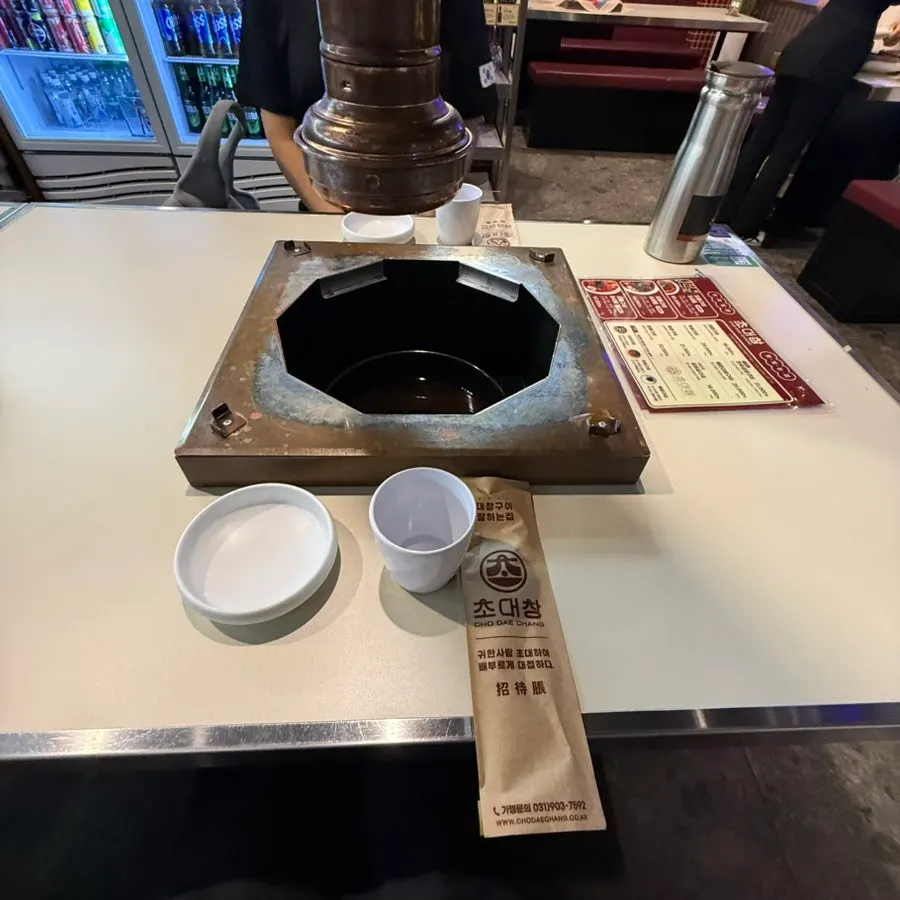 View of seating and grill pans at Chodaechang Baekseok Branch