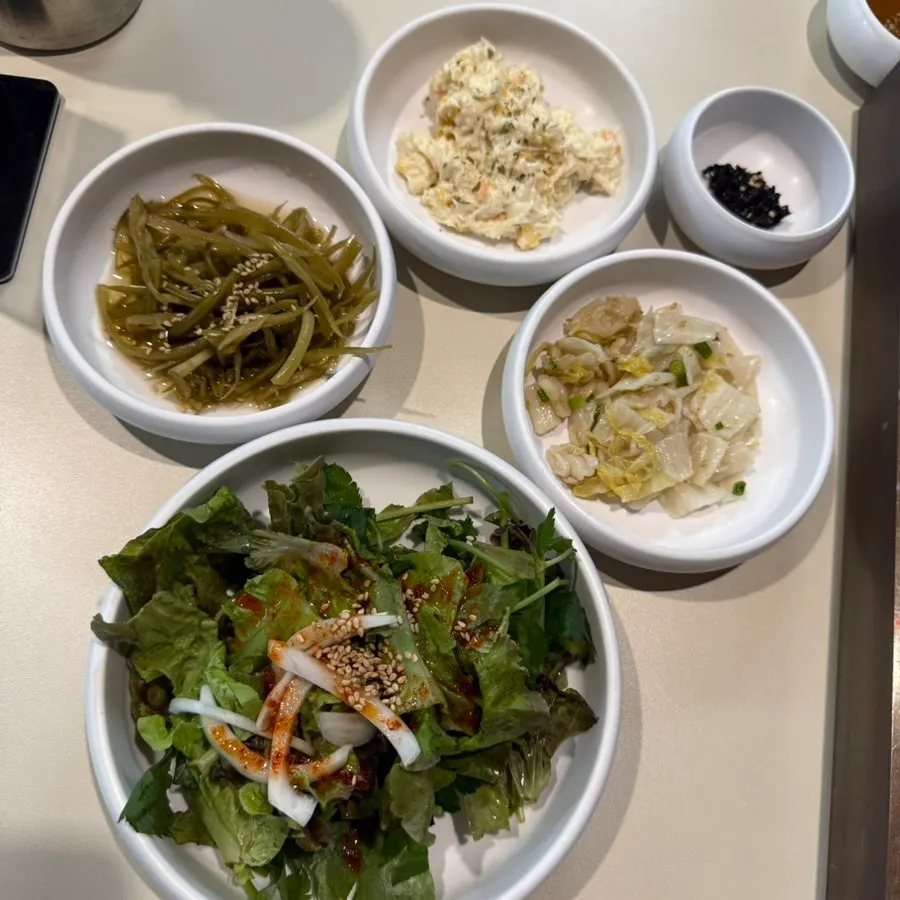Plates of accompanying side dishes at Chodaechang Baekseok Branch