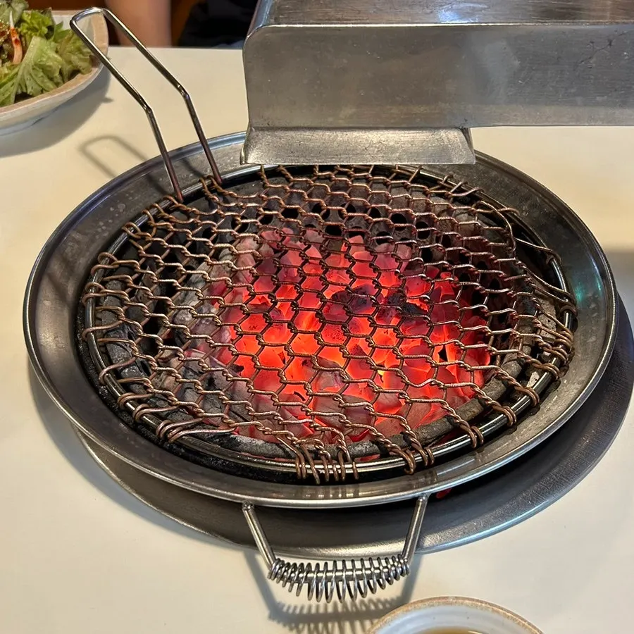 테이블에 들어온 숯불과 불판