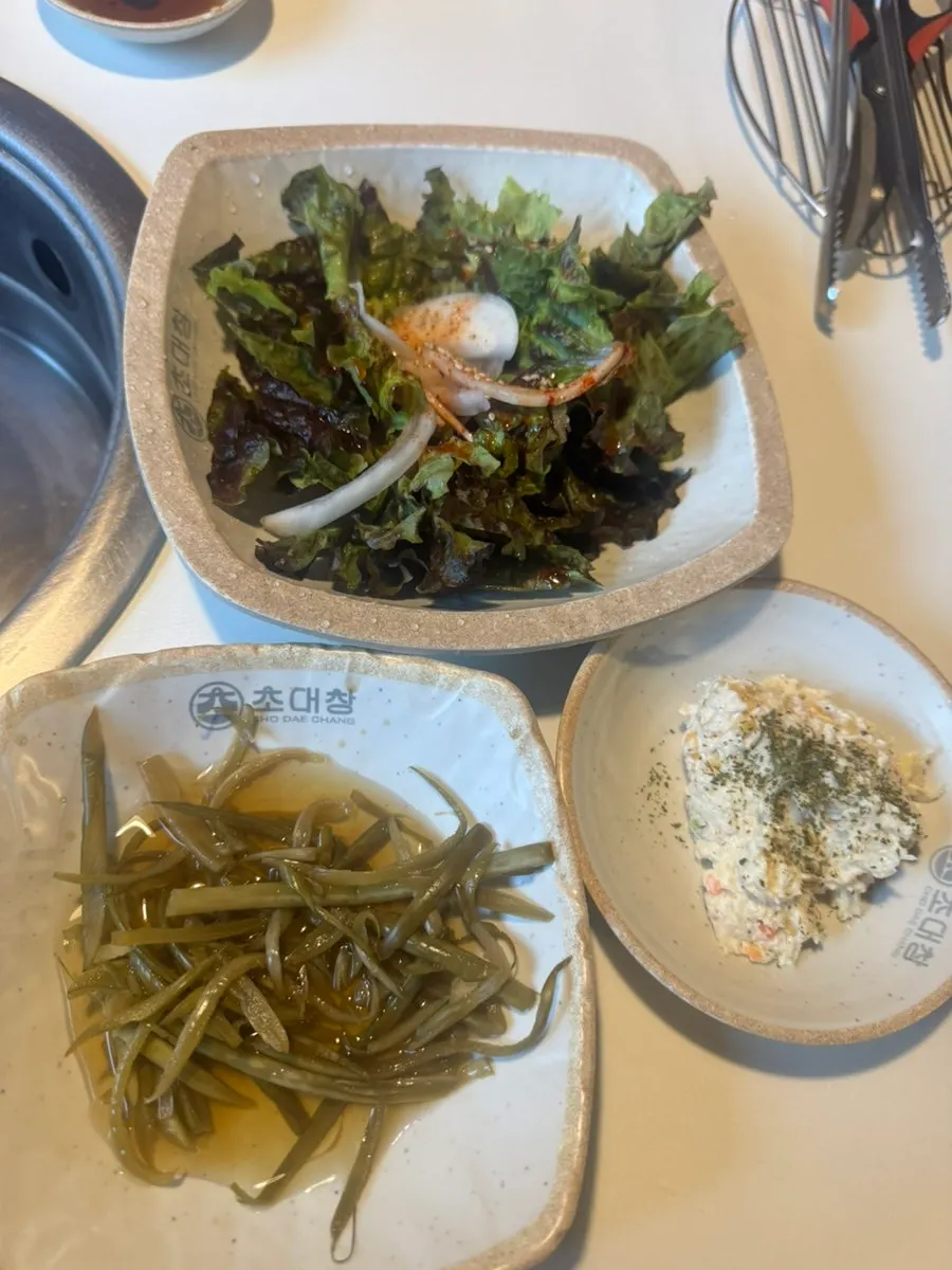 Table setting with seasoned lettuce salad and pickled peppers as banchan