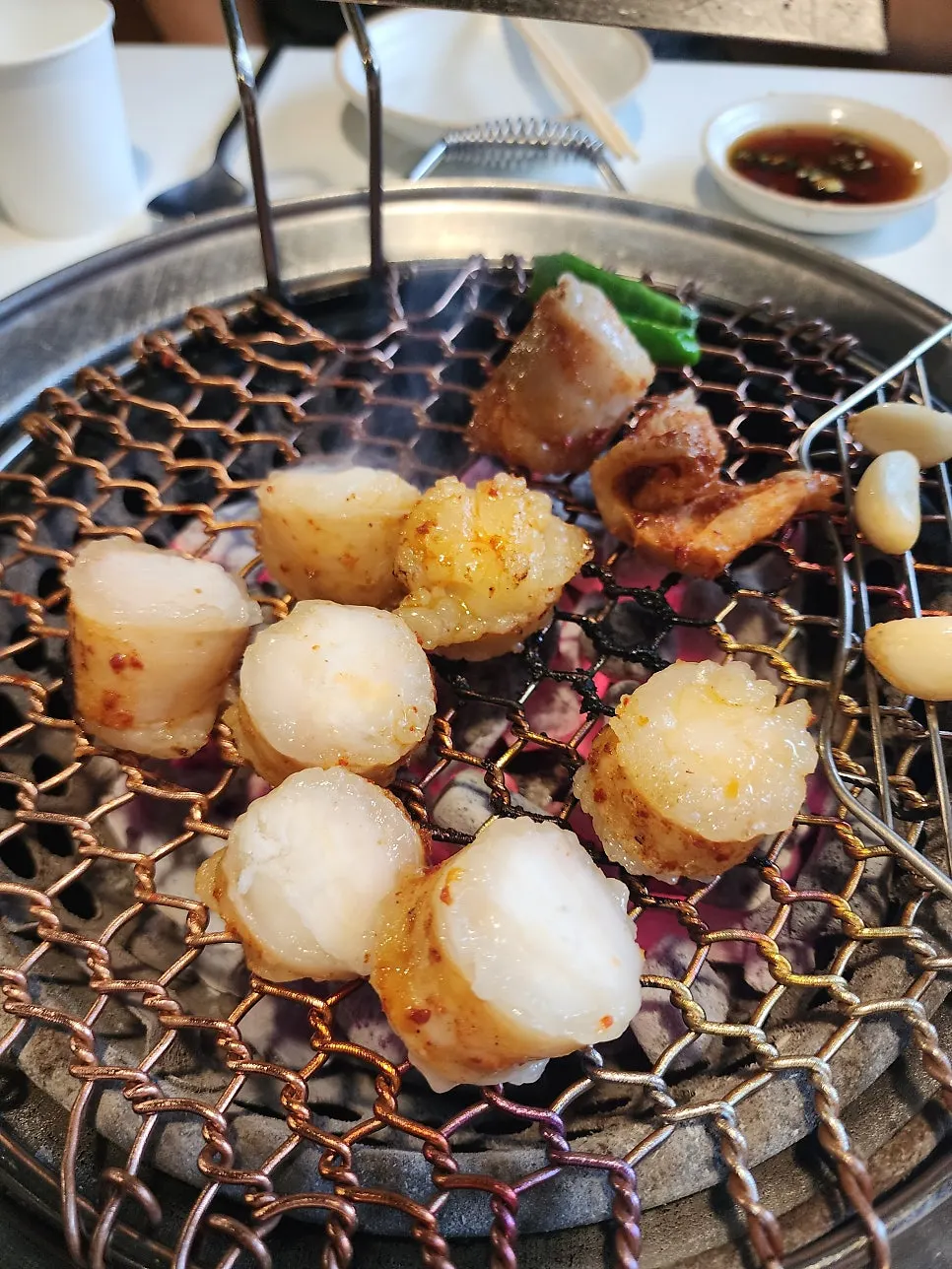 店員が網の上の大腸と特陽を焼いている様子