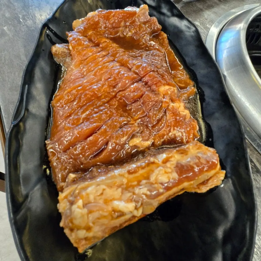 숯불 위에 올린 초당우가 양념 돼지갈비