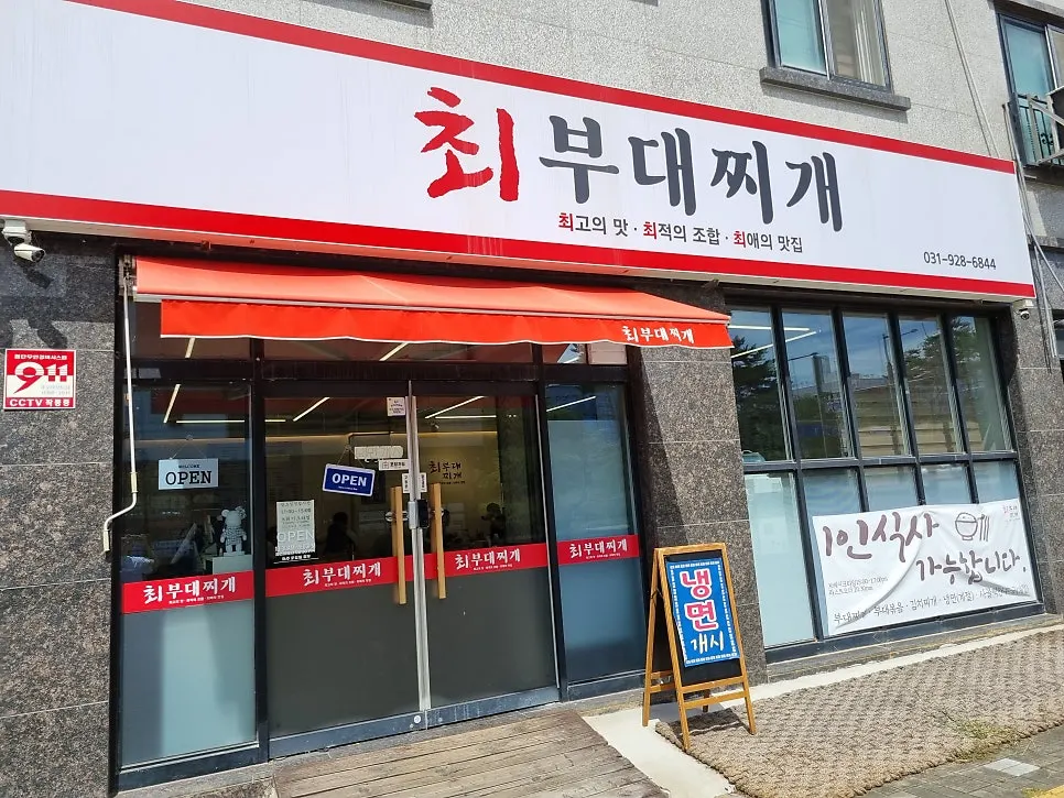 Solo dining welcome sign on Choi Budae Jjigae's storefront glass