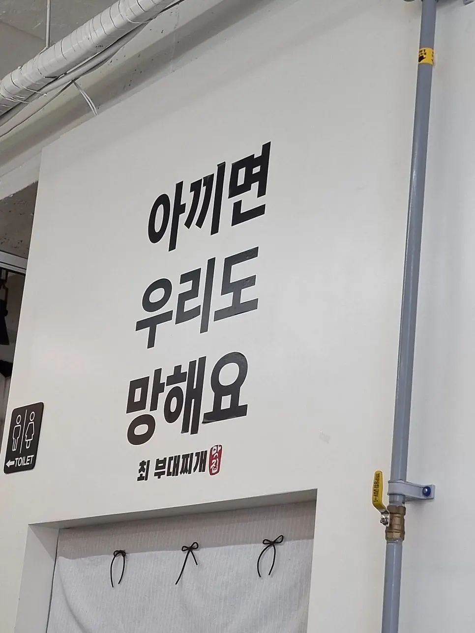 Business philosophy sign on the wall of Choi Budae Jjigae