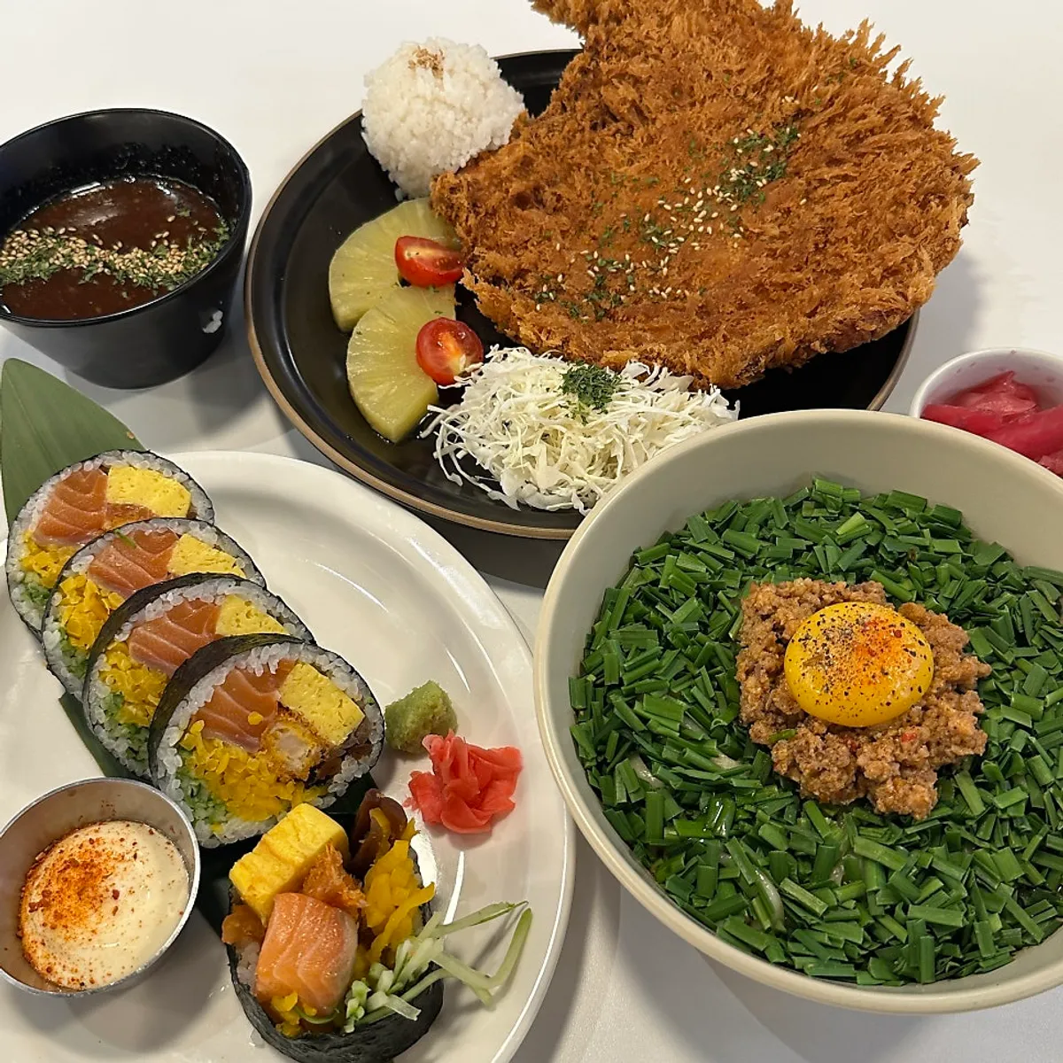 Full spread of futomaki, bone-in pork katsu, and maze soba