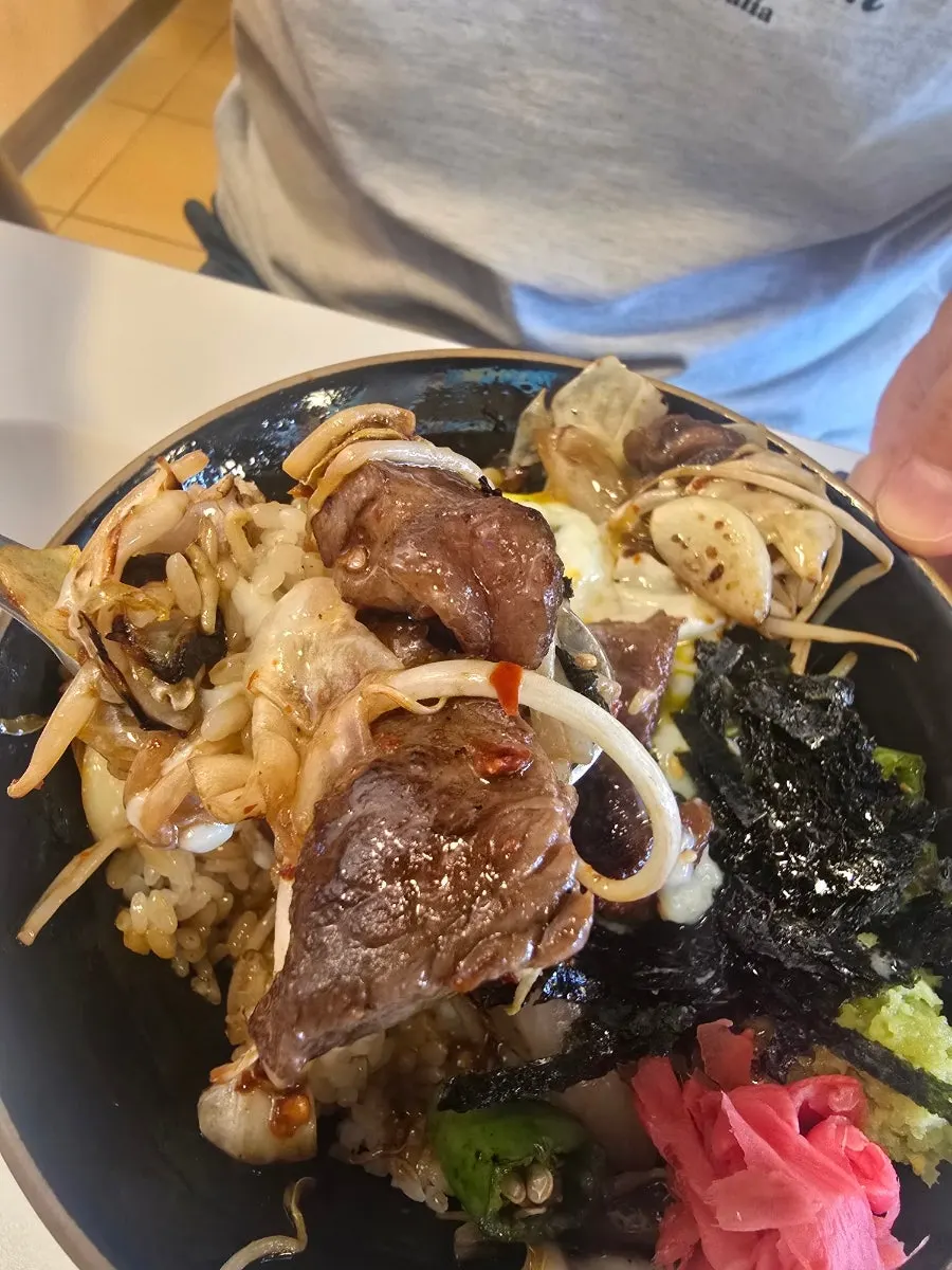 Thick steak scooped up together with rice